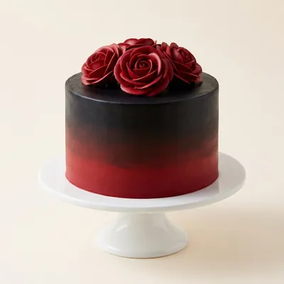 Pastel con degradado de negro a rojo y rosas rojas de crema encima