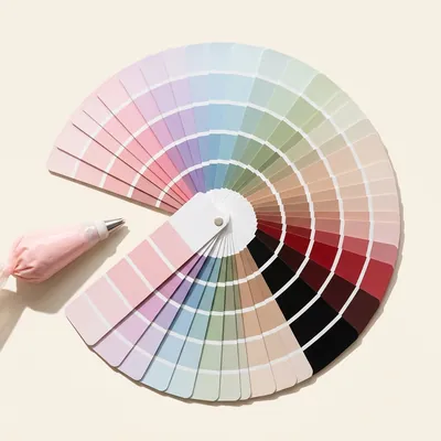 Abanico de muestras de color en tonos pastel, rojos y negros junto a una manga pastelera